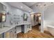 A luxurious primary bathroom with wood flooring, glass shelving, and ample lighting at 710 Devon Hill Ct, Roswell, GA 30075