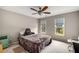 Cozy bedroom with carpet, two windows, and ceiling fan at 710 Devon Hill Ct, Roswell, GA 30075