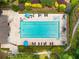 Aerial view of a community pool with sunbathers, lush landscaping, and a lounge area with tables and chairs at 710 Devon Hill Ct, Roswell, GA 30075
