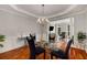 Elegant dining room featuring a glass table, decorative chandelier, and an open floor plan at 710 Devon Hill Ct, Roswell, GA 30075