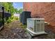 Exterior view of home's generator, a/c unit, brick wall, and landscaping at 710 Devon Hill Ct, Roswell, GA 30075