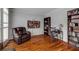 Cozy living room with hardwood floors, a comfortable leather recliner, and built-in bookshelves at 710 Devon Hill Ct, Roswell, GA 30075