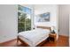 Bedroom features a large window, wood floors, a queen bed, and nightstands with lamps at 1195 Milton Se Ter # 1407, Atlanta, GA 30315