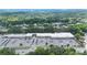 Aerial view of shopping center, parking lot, and surrounding buildings in a wooded area at 305 Winding River Village Dr # F, Atlanta, GA 30350