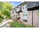 Brick and siding exterior of townhome with manicured lawn and black trim and stair railing at 305 Winding River Village Dr # F, Atlanta, GA 30350