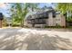 Exterior view of a multi-story apartment building with balconies and mature trees at 305 Winding River Village Dr # F, Atlanta, GA 30350