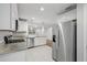 Bright, updated kitchen with granite countertops, stainless steel appliances, and white tile flooring at 305 Winding River Village Dr # F, Atlanta, GA 30350