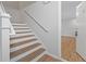 Staircase leading to entry door with wood and white paneled stairs and white walls at 305 Winding River Village Dr # F, Atlanta, GA 30350