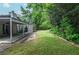 A spacious backyard with a covered patio, lush greenery, and a well-manicured lawn at 5697 Brooklyn Ln, Norcross, GA 30093