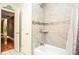 Modern bathroom featuring a tiled shower over tub combination with decorative mosaic tile details at 5697 Brooklyn Ln, Norcross, GA 30093
