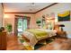 Staged main bedroom includes neutral colors, and access to patio with green and yellow accents at 5697 Brooklyn Ln, Norcross, GA 30093