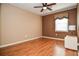 Bedroom featuring wood floors, a ceiling fan, window with privacy blinds, and neutral paint at 5697 Brooklyn Ln, Norcross, GA 30093