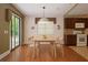 Bright dining room featuring wood floors and a modern lighting fixture above a wood table at 5697 Brooklyn Ln, Norcross, GA 30093