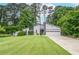 Charming gray home with manicured lawn and two-car garage nestled among mature trees at 5697 Brooklyn Ln, Norcross, GA 30093