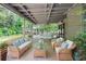 Staged covered outdoor living area features wicker furniture and backyard views at 5697 Brooklyn Ln, Norcross, GA 30093