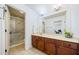 Clean bathroom with vanity, modern countertop, large mirror, walk-in shower, and neutral tones at 8360 Village School Dr, Cumming, GA 30041