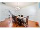 Dining room with hardwood floors and modern chandelier, offering staircase and living room views at 8360 Village School Dr, Cumming, GA 30041