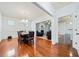 Elegant dining room with hardwood floors, modern chandelier, and views into the living room at 8360 Village School Dr, Cumming, GA 30041