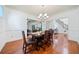 Dining room with hardwood floors, chandelier, and views into the living room and foyer at 8360 Village School Dr, Cumming, GA 30041