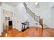 Hardwood foyer with staircase, stylish console table, and view into the kitchen at 8360 Village School Dr, Cumming, GA 30041