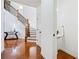 Bright entryway with hardwood floors, staircase with dark banister, white trim, and a powder room at 8360 Village School Dr, Cumming, GA 30041