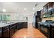 Modern kitchen featuring granite counters, dark cabinets and steel appliances at 8360 Village School Dr, Cumming, GA 30041