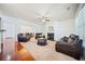Bright living room with a fireplace, ceiling fan, and comfortable leather seating at 8360 Village School Dr, Cumming, GA 30041