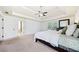 Bright main bedroom featuring a tray ceiling, fan, and neutral-toned carpet and walls at 8360 Village School Dr, Cumming, GA 30041