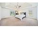 Spacious main bedroom with high ceilings, ceiling fan, natural light and plush carpeting at 8360 Village School Dr, Cumming, GA 30041
