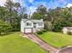 Charming home featuring a one-car garage, light-green siding, and a beautifully landscaped front yard at 2485 Shady Shoals Ct, Decatur, GA 30034