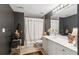 Stylish bathroom with double sink vanity, decorative mirror and tiled shower, with dark accent wall at 2840 Astoria Ave, Cumming, GA 30040