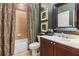 Well-lit bathroom with a vanity and mirror, with a shower/tub and neutral-toned tile and patterned shower curtain at 2840 Astoria Ave, Cumming, GA 30040
