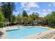 An immaculate community pool with multiple lounge chairs and umbrellas on a sunny day at 2840 Astoria Ave, Cumming, GA 30040