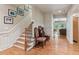Inviting foyer boasts hardwood floors, staircase with white trim, with decoratively adorned chairs nearby at 2840 Astoria Ave, Cumming, GA 30040