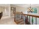 Beautiful hallway and staircase with carpet, railing, chandelier, and natural light from the front doors at 2840 Astoria Ave, Cumming, GA 30040