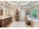 Luxurious main bathroom with dual vanities, soaking tub, a glass-enclosed shower, and travertine floors at 2840 Astoria Ave, Cumming, GA 30040