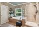 Luxurious main bathroom with dual vanities, soaking tub, a glass-enclosed shower, and travertine floors at 2840 Astoria Ave, Cumming, GA 30040