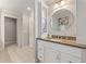 Well-lit bathroom showcases a modern vanity with a round mirror, granite countertops, and tiled floors at 1042 Trailridge Pl, Atlanta, GA 30338