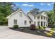 A side view showcasing the home's pristine white facade, elegant landscaping, and well-maintained driveway at 1042 Trailridge Pl, Atlanta, GA 30338