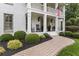 Inviting covered front porch with rocking chairs, decorative plants, and a charming brick walkway at 1042 Trailridge Pl, Atlanta, GA 30338