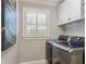 Laundry room with stainless steel washer and dryer and built-in shelving at 1042 Trailridge Pl, Atlanta, GA 30338