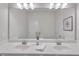 Bright bathroom featuring a white vanity with double undermount sinks, large mirror and decorative vases at 6179 Ashbranch Dr, Acworth, GA 30101