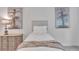 Well-lit bedroom featuring a bed with neutral bedding, dresser and attractive decorative paintings at 6179 Ashbranch Dr, Acworth, GA 30101