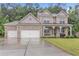 Charming two-story brick home with a three-car garage and well-manicured lawn and a cozy porch at 6179 Ashbranch Dr, Acworth, GA 30101