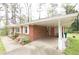 Exterior view of a well-maintained home with a brick facade, carport, and charming landscaping in a serene setting at 1693 Montreal Rd, Tucker, GA 30084
