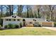 Charming ranch-style home with white painted brick, dormers, manicured lawn and mature trees at 1978 Fisher Trl, Atlanta, GA 30345