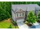 Aerial view of a brick townhome featuring a two-car garage and manicured landscaping at 2006 Towneship Trl, Roswell, GA 30075