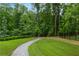 Gravel path through a green, landscaped backyard with mature trees providing shade and privacy at 2006 Towneship Trl, Roswell, GA 30075