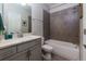 Well-lit bathroom with a shower-tub combo, gray tiling, and a modern vanity with storage at 2006 Towneship Trl, Roswell, GA 30075
