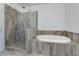 Elegant bathroom featuring a large soaking tub with tile surround and glass enclosed shower at 2006 Towneship Trl, Roswell, GA 30075